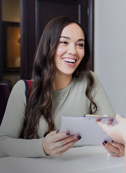 Smiling woman receiving a clipboard. 