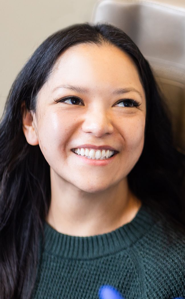 Smiling woman with dark hair and sweater.