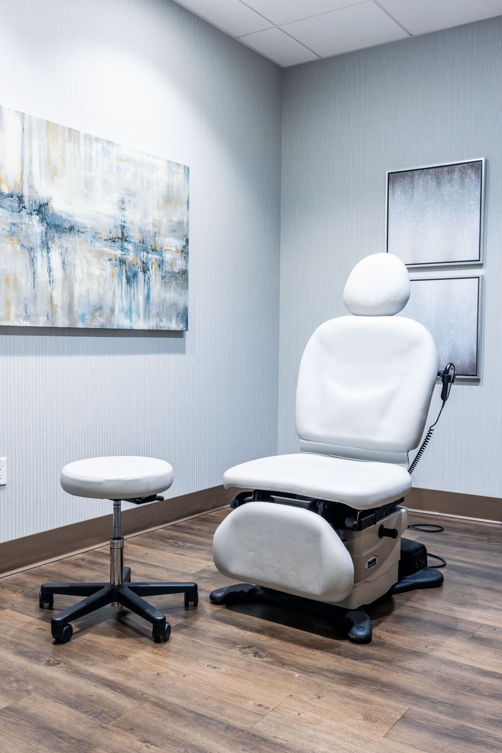 Medical examination room with chairs and artwork.