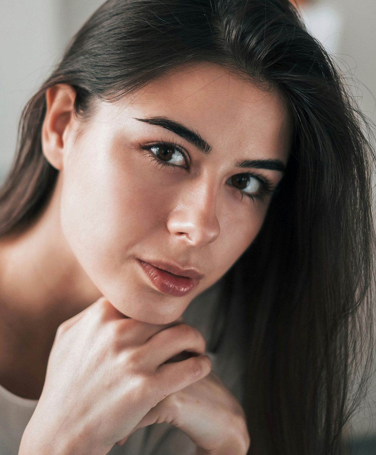 San Diego Otoplasty model with long hair, resting her chin.