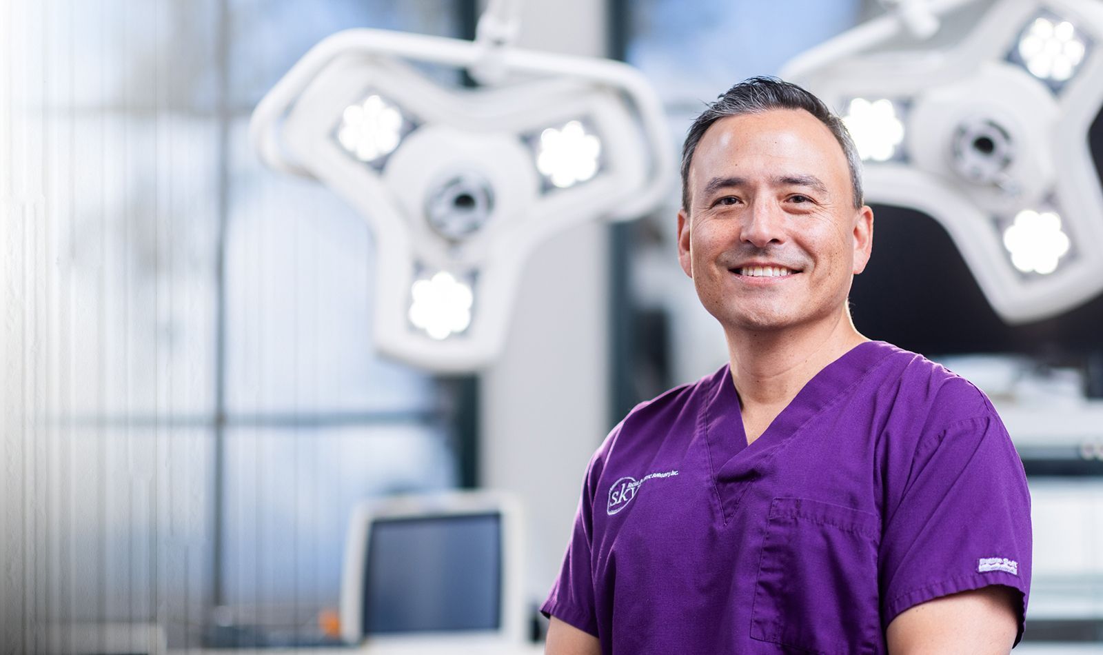 Smiling healthcare professional in surgical environment.