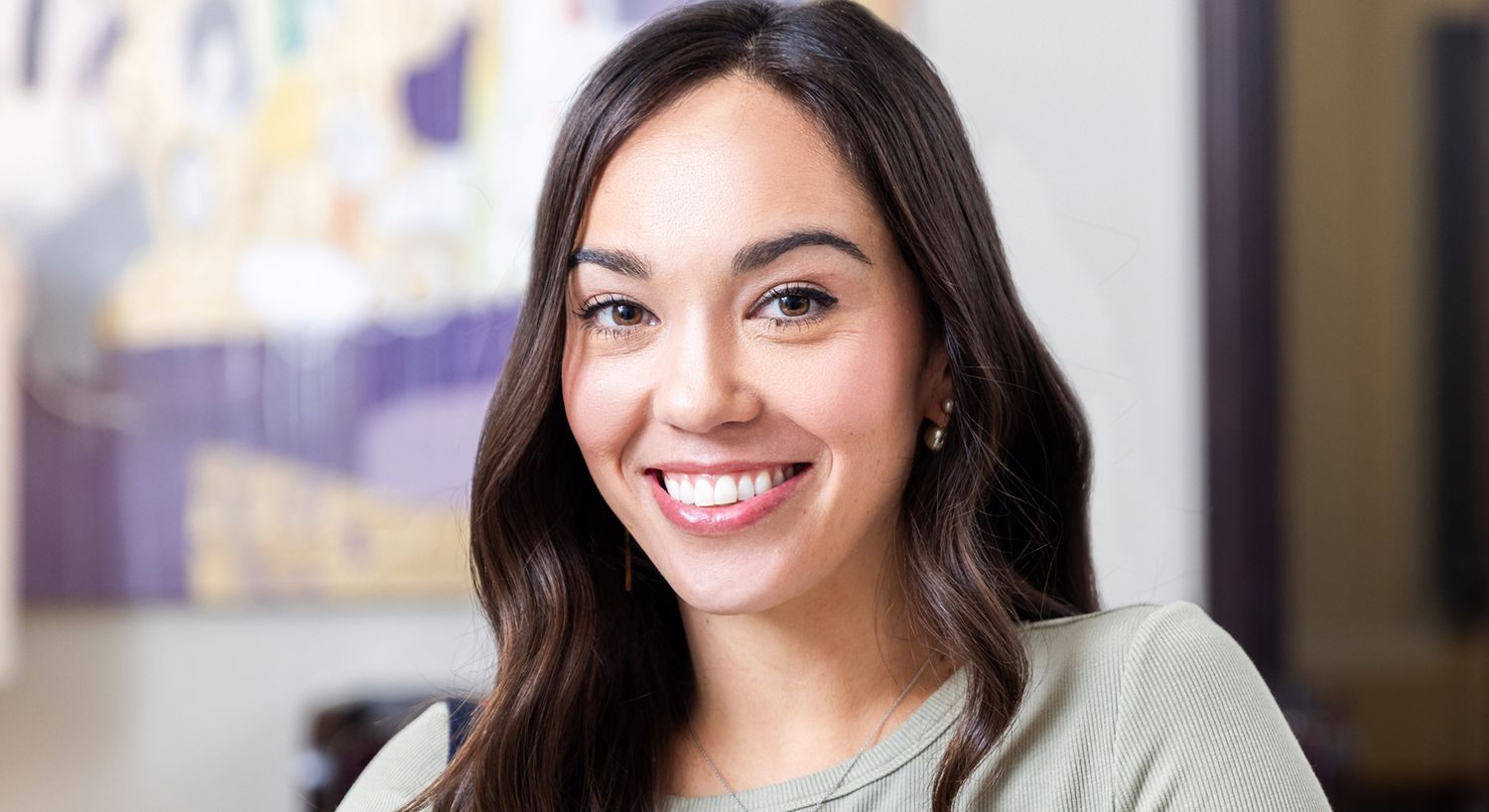 Smiling woman with long hair in casual setting.